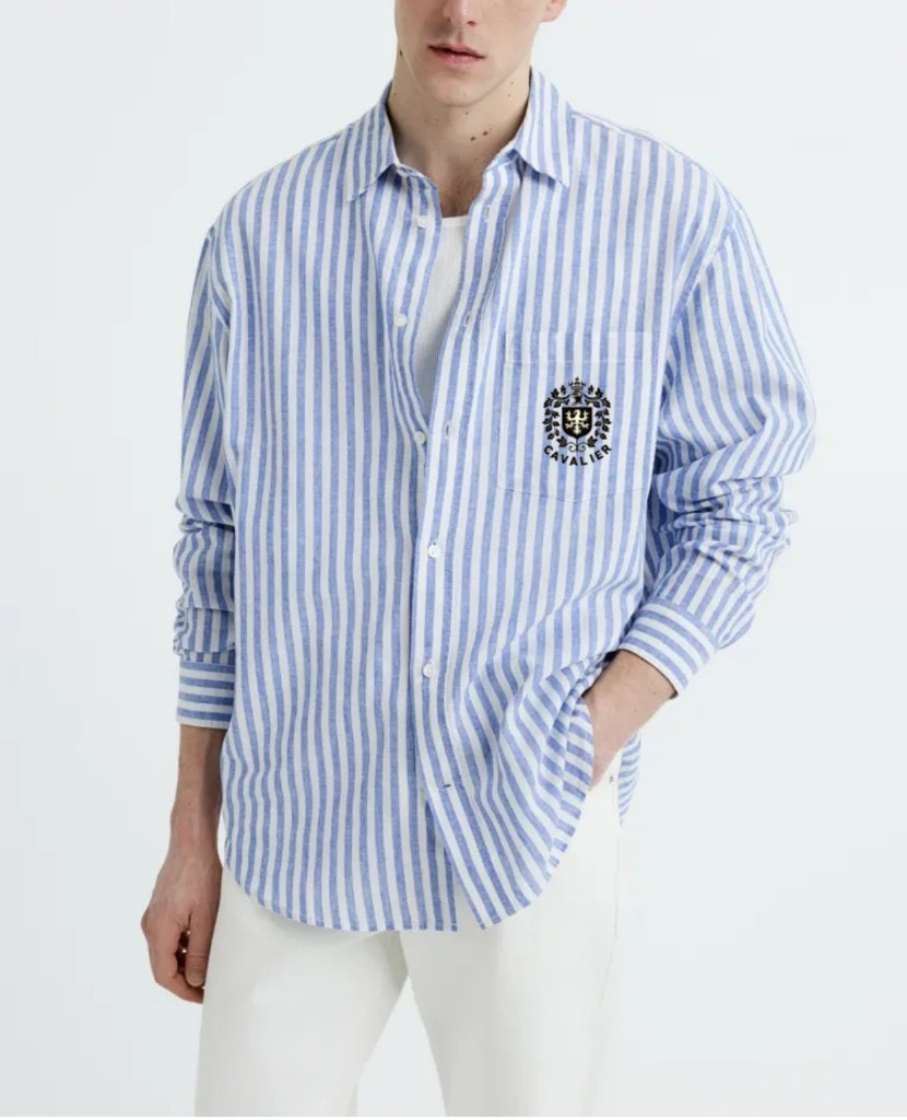Model wearing a striped Cavalier shirt with embroidered crest logo.