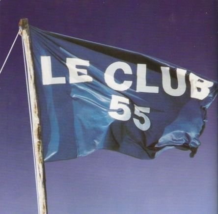 Dark blue Le Club 55 flag against a purple sky.