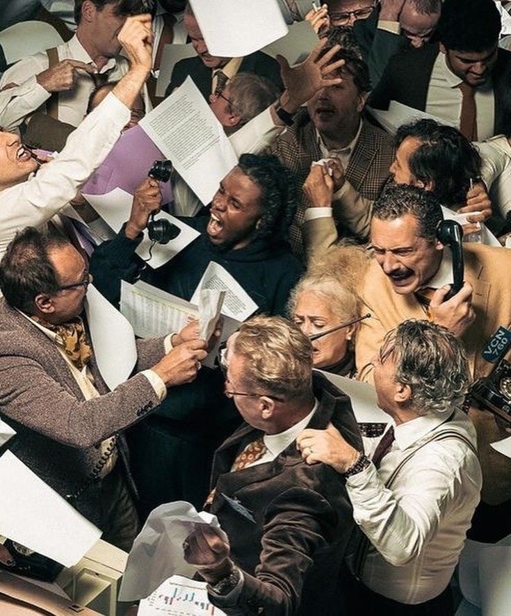 Crowded vintage trading floor with brokers shouting and waving tickets.